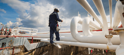 Worker checking rust on pipes.